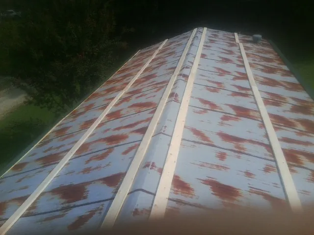 Rusted metal roof panels with new wood purlins before replacement — Storm Damage Roof Repair in Lamy by Roofing Brothers