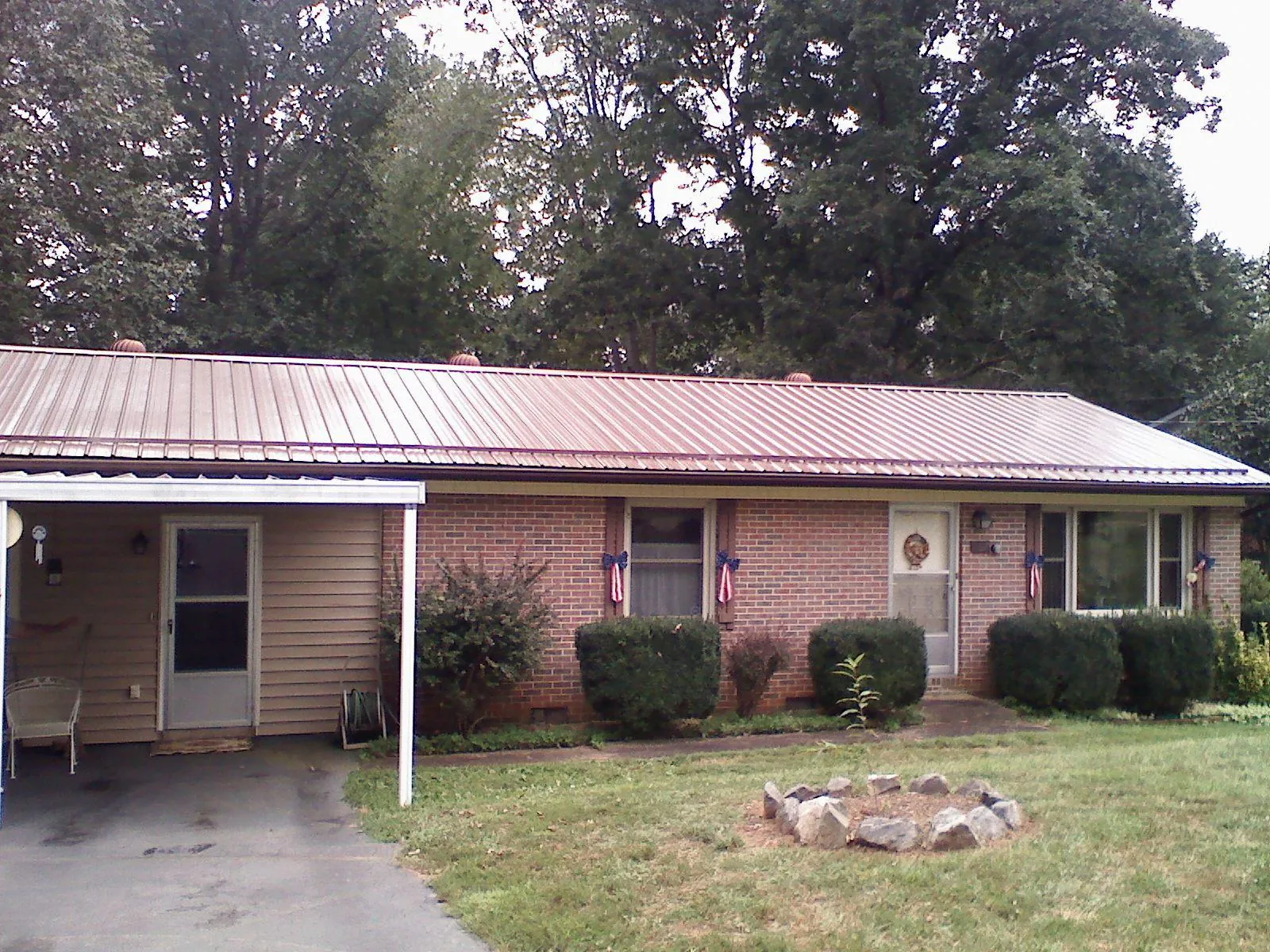 Bronze metal roof and carport on a brick ranch home — Roof Repair work by our crew in Lamy